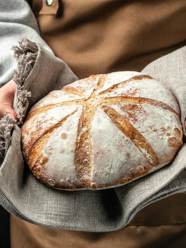 Homemade sourdough bread in hand. Healthy food concept. place for text, top view